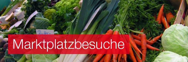 Die Auslage eines Gemüsehändlers mit verschiedenen Gemüsesorten, Aufschrift: Marktplatzbesuche